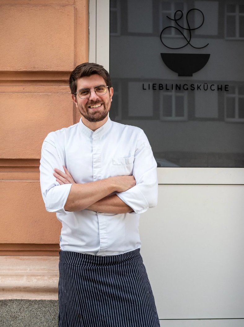 Florian Mükisch, Gründer der Lieblingsküche, lächelnd vor seinem Restaurant in Wien-Meidling